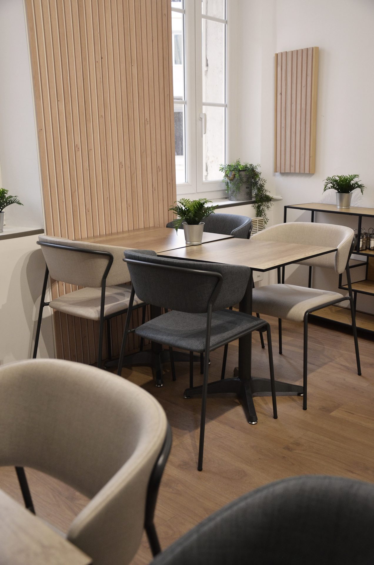 Salle du restaurant Iki Guys avec panneaux acoustiques bois et fauteuils rembourrés